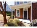 Inviting front entrance with brick columns, black door and lantern lighting at 4748 Longcourt Se Dr, Atlanta, GA 30339