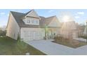 Two-story home with light gray siding, stone accents, and a large driveway at 187 Hickory Bluffs Pkwy, Canton, GA 30114