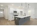 Modern kitchen with white cabinets, gray island, quartz countertops, and stainless steel appliances at 907 Agate Ln, Lawrenceville, GA 30043
