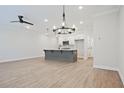 Open living space with hardwood floors, ceiling fan, chandelier, and access to kitchen at 907 Agate Ln, Lawrenceville, GA 30043