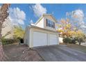 Tan house with a two-car garage and landscaping at 2213 Asquith Sw Ave, Marietta, GA 30008