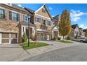 Townhome with a stone and brick exterior, a two-car garage, and a paved driveway at 3233 Nobility Se Way, Vinings, GA 30339