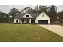 Modern farmhouse with white siding, black roof and accents, large windows, and a green lawn at 236 Harmony Ridge Dr, Temple, GA 30179