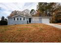 Single-story home with a gray exterior, black shutters, and a large front yard at 5760 Lakeview Dr, Powder Springs, GA 30127