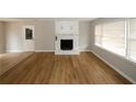 Open living room featuring wood-look floors and a white brick fireplace at 5760 Lakeview Dr, Powder Springs, GA 30127