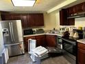 Kitchen features dark wood cabinets and stainless steel appliances at 3344 Creekwood Dr, Rex, GA 30273