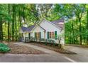 House exterior showcasing a white facade, green shutters, and a tree-lined driveway at 3684 Regent Nw Dr, Kennesaw, GA 30144