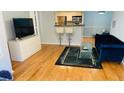 Open living space with hardwood floors, kitchen access, and a view of the kitchen at 1005 Chastain Park Ne Ct # 1005, Atlanta, GA 30342