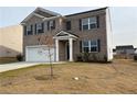 Two-story brick home with a white garage door and landscaping at 2125 Waycross Ln, Dacula, GA 30019