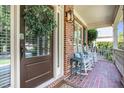 Inviting front porch with rocking chairs, brick flooring, and a charming wreath at 552 Grassmeade Way, Snellville, GA 30078