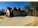 Three-car garage with a paved driveway and landscaped yard at 1560 Tapestry Rdg, Lawrenceville, GA 30045