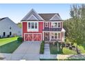 A charming two-story red home with a front porch and attached garage at 100 Academy Ln, Canton, GA 30114