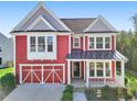 Inviting red two-story home featuring a front porch and attached garage at 100 Academy Ln, Canton, GA 30114