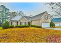 Brick home with a two-car garage and autumn leaves at 394 Grand Ashbury Ln, Sugar Hill, GA 30518