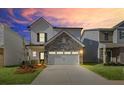 Inviting two-story home with a stone and siding exterior, front yard landscaping, and attached two-car garage at sunset at 2700 Ravencliff Dr, Austell, GA 30168