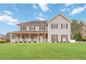 Two-story home with a stone and siding exterior, front porch, and green lawn at 2765 Hunters Pond Ln, Snellville, GA 30078