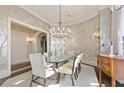 Formal dining room with glass table, chandelier, and scenic wallpaper at 3376 Peachtree Ne Rd # 47A, Atlanta, GA 30326