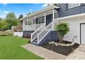 Charming front porch with white railings, a porch swing, and lush landscaping at 3665 Sharon Dr, Powder Springs, GA 30127