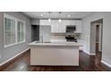 Modern kitchen featuring white cabinets, granite countertops, and a large island at 1544 Childress Sw Dr, Atlanta, GA 30311