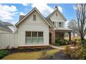 Two-story home with white siding, brick accents, and American flag at 304 Woodstock Seven Dr, Woodstock, GA 30188