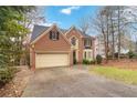 Two-story house with a large driveway and mature trees at 4830 Chesterfield Ct, Suwanee, GA 30024