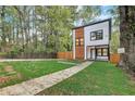 Modern two-story house with wood and white exterior, landscaped lawn, and fenced yard at 1930 Pinedale Nw Dr, Atlanta, GA 30314