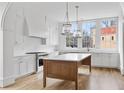 Modern kitchen with white cabinets, quartz countertops, and a wood island at 90 Sheridan Dr, Atlanta, GA 30305
