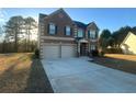 Two-story brick home with a three-car garage and a spacious driveway at 5979 Rex Ridge Ct, Rex, GA 30273