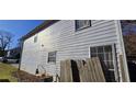 Side view of a two-story house with light gray vinyl siding and a damaged fence at 1041 Heritage Valley Rd, Norcross, GA 30093