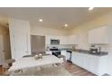 Modern kitchen with white cabinets, stainless steel appliances, and breakfast bar at 301 Hynes Sw Dr, Villa Rica, GA 30180