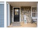 Welcoming front porch with a black door and stone accents at 10490 Plantation Bridge Dr, Alpharetta, GA 30022