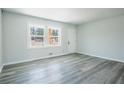 Living area with gray wood-look flooring, white walls, a window, and door at 1004 Forrest Se Dr, Atlanta, GA 30354