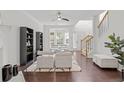 Living room with hardwood floors, white sofas, and a built-in bookcase at 112 Timber Mist Ln, Lawrenceville, GA 30045