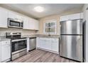 Updated kitchen boasts white cabinets, stainless steel appliances, and granite countertops at 1767 Big Horn Se Ct, Conyers, GA 30013