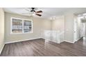 Bright living room with wood-look flooring, ceiling fan, and staircase at 1767 Big Horn Se Ct, Conyers, GA 30013