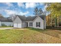 Gray house with two-car garage and spacious yard at 1299 Paddocks Way, Powder Springs, GA 30127