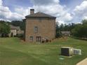 Side view of a two-story brick home with a grassy backyard at 1880 Hays Farm Walk, Marietta, GA 30064