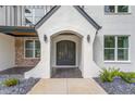 Elegant front entry with a black arched double door and white brick columns at 2626 Sardis Way, Buford, GA 30519