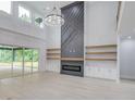 Open living area with a modern fireplace, built-in shelves, and large windows at 2626 Sardis Way, Buford, GA 30519
