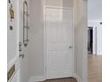 Simple entryway with a white door, wall-mounted shelving, and wood-look flooring at 6851 Roswell Rd # D14, Atlanta, GA 30328