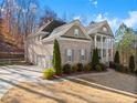 Two-story brick home with attached three-car garage and landscaped yard at 1222 Wisteria Bluff Ct, Hoschton, GA 30548