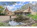 Backyard with a pond, screened porch, and lush landscaping at 7865 Nesbit Ferry Rd, Sandy Springs, GA 30350