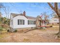 View of the side of a white, single-story house with dark shutters and a red porch at 8451 Duncan St, Douglasville, GA 30134