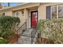 Red front door and stone steps welcome you to this charming home at 1245 Brook Forest Ne Dr, Atlanta, GA 30324