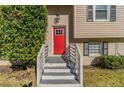 Red front door with a glass panel, white railing, and shrubs at 633 Larchmont Nw Cir, Atlanta, GA 30318