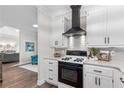 Modern kitchen with white cabinets, black appliances, and sleek range hood at 2085 Melrose Trce, Cumming, GA 30041