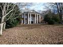 Stately brick home with towering columns and autumn leaves at 1378 Wesley Oaks Nw Ct, Atlanta, GA 30327