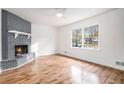 Bright living room with wood floors, a cozy fireplace, and large windows overlooking the front yard at 6709 Londonderry Dr, Morrow, GA 30260