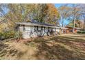 Ranch house with mature trees and a grassy yard at 2126 River Rd, Ellenwood, GA 30294