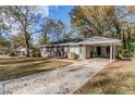 Front view of a ranch house with a carport and landscaping at 2126 River Rd, Ellenwood, GA 30294